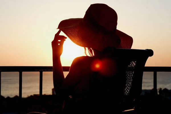 Silueta de una chica en una silla sobre un fondo natural — Foto de Stock