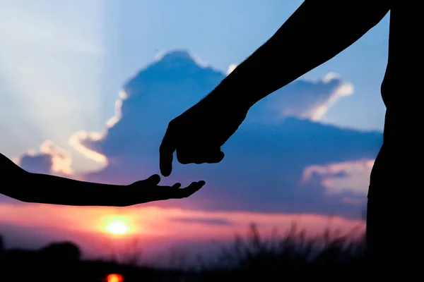 Hands of parent and child silhouette on nature — Stock Photo, Image