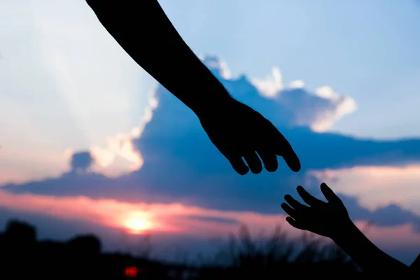 Hands of parent and child silhouette on nature — Stock Photo, Image