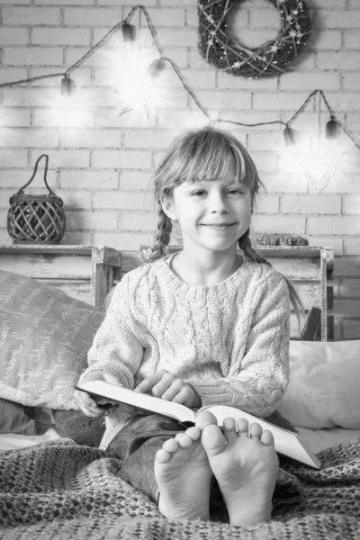 Criança feliz lendo um livro no Natal — Fotografia de Stock