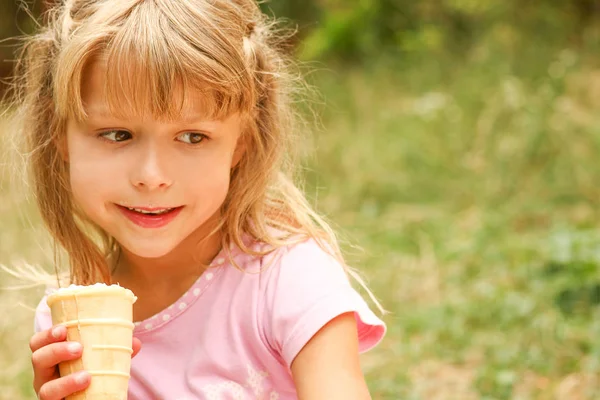 Boldog gyermek eszik fagylaltot a szabadban a parkban — Stock Fotó