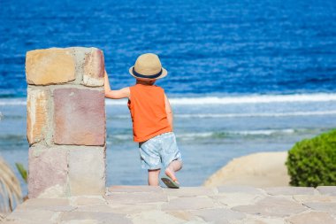 Mutlu çocuk deniz arka plan üzerinde oynarken