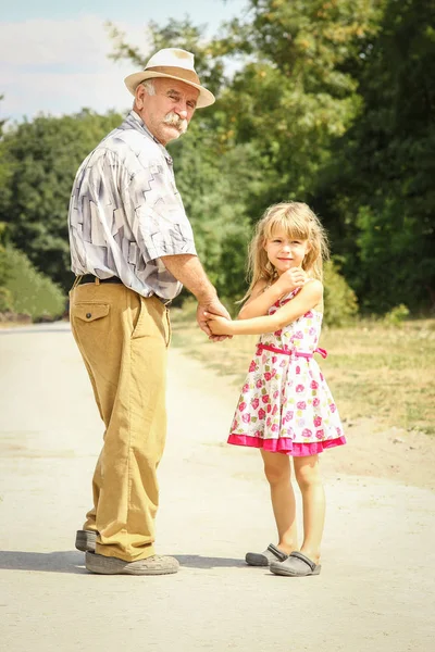 快乐的祖父在去公园的路上带着一个孩子散步 — 图库照片