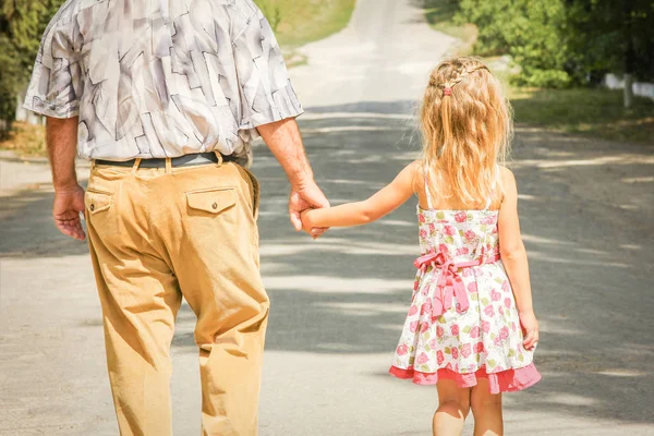 Abuelo feliz caminando con un niño en su camino al parque — Foto de Stock