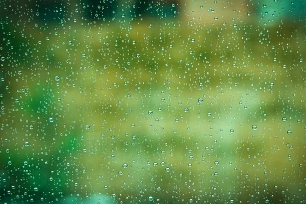 Belas gotas no vidro no fundo do parque — Fotografia de Stock