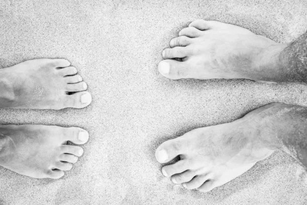 Beautiful legs on sand near the sea shore on nature background — Stock Photo, Image