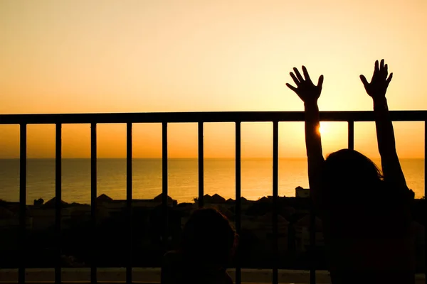 Happy child at the time of the silhouette of the sea background — Stock Photo, Image