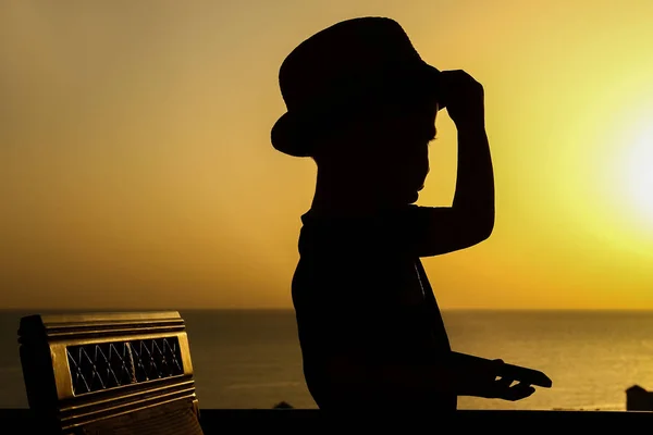 Happy child in hat silhouette on sea background — Stock Photo, Image