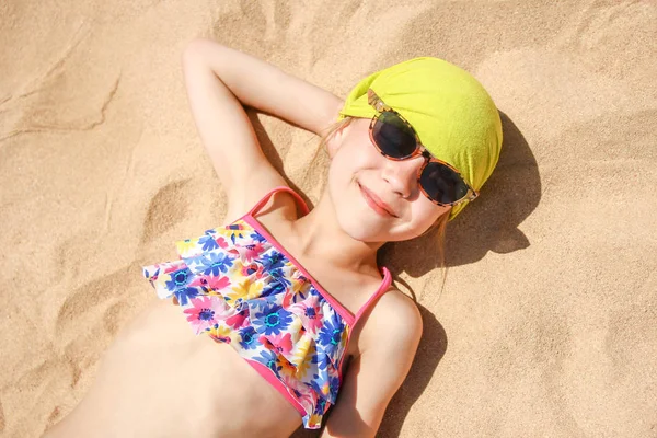 Felice bambino in occhiali prendere il sole sulla riva del mare sfondo — Foto Stock