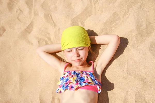 Happy child in glasses sunbathing on the seashore background — Stock Photo, Image