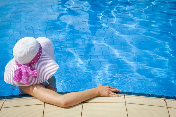 Happy girl in a hat by the pool at sea — Stock Photo, Image