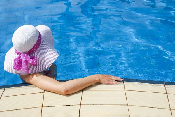 Счастливая девушка в шляпе у бассейна на море — стоковое фото