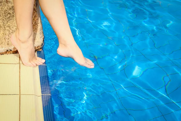 Mooie benen van een meisje in de buurt van een zwembad aan de zee backgro — Stockfoto