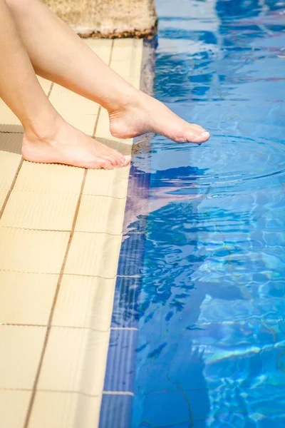 Schöne Beine eines Mädchens in der Nähe eines Swimmingpools auf dem Meer backgro — Stockfoto