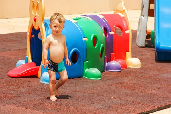 Happy child plays on a playground by the sea — Stock Photo, Image