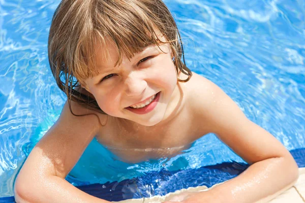 Een gelukkig kind bij het zwembad op zee — Stockfoto
