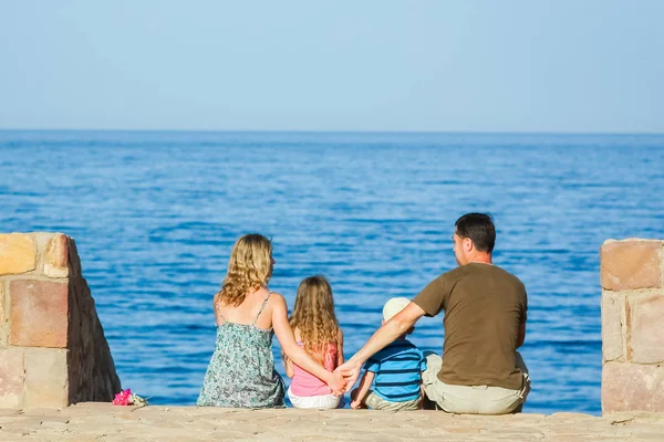 Happy parents with children playing on the sea background — Stock Photo, Image