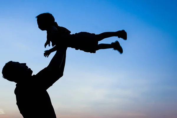 Père parent heureux avec silhouette de bébé dans un parc sur la nature — Photo