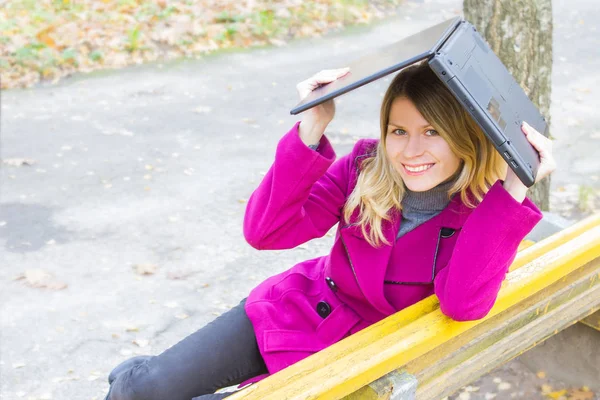 Счастливая девушка с ноутбуком на природе в осеннем парке — стоковое фото