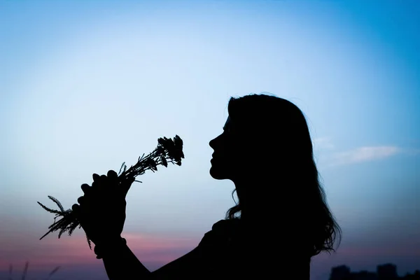 Ragazza felice con una silhouette bouquet sulla natura nel parco sunse — Foto Stock