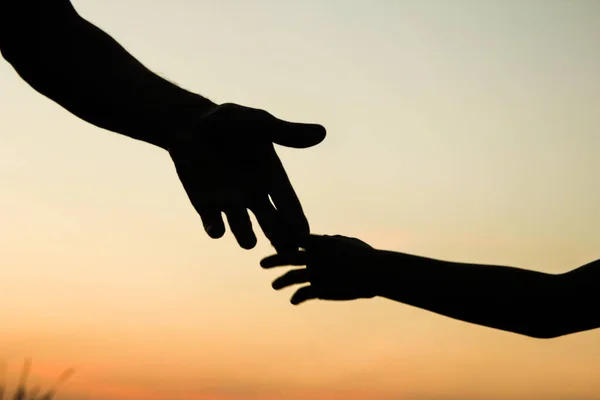 Felice padre genitore con bambino silhouette mano al tramonto in natur — Foto Stock