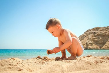 Mutlu çocuk deniz arka plan üzerinde oynarken