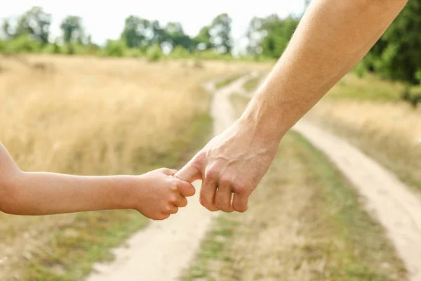 Stylish hands of a parent and child in the nature in a park back — Stock Photo, Image