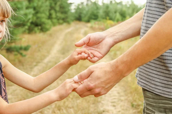 Les mains élégantes d'un parent et d'un enfant dans la nature dans un parc retour — Photo