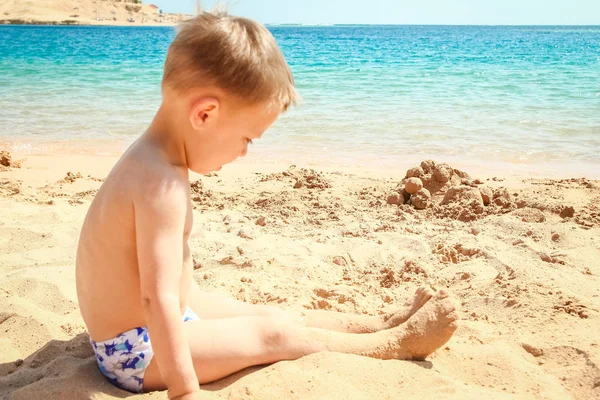 Felice bambino che gioca sullo sfondo del mare — Foto Stock