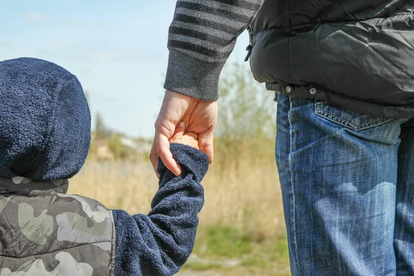 Стильные руки родителя и ребенка на природе в парке назад — стоковое фото