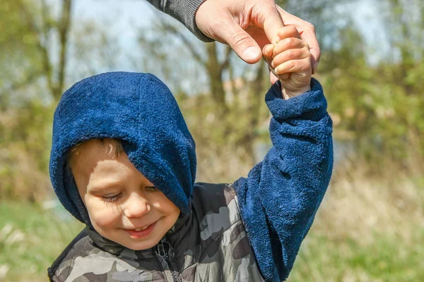 Stylish hands of a parent and child in the nature in a park back — Stock Photo, Image