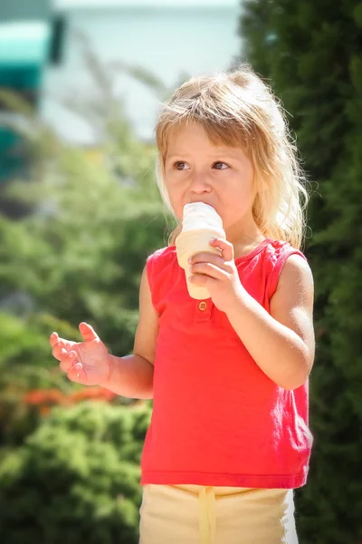 Счастливый ребенок ест мороженое на природе парка — стоковое фото