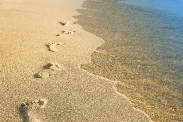 Mooie voetafdrukken in het zand in de buurt van de zee op de natuur backgrou — Stockfoto