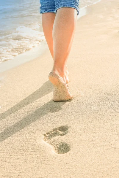 Schöne Spuren mit Füßen am Meer auf Naturhintergrund — Stockfoto