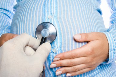 Mutlu hamile kız beyaz arka planda yatıyor.