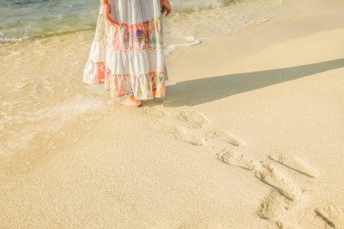 Ayakları kumsalda güzel ayak izleri.