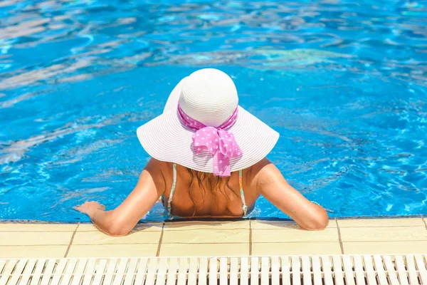 Šťastná dívka v klobouku u bazénu na břehu moře — Stock fotografie