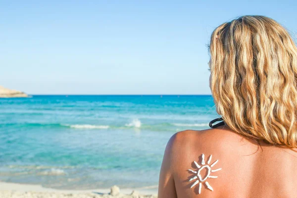 Glückliches Mädchen mit der Sonne auf dem Rücken am Meer in der Natur — Stockfoto