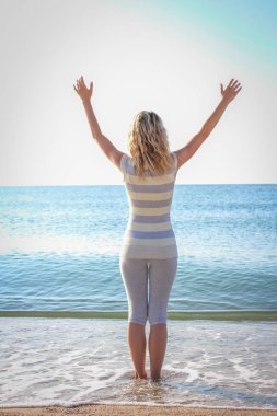 Açık denizde sırtında bir kalple mutlu bir kız.