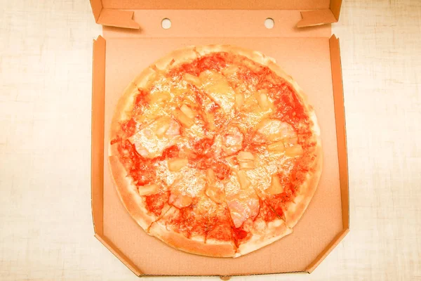 Gorący kawałek pizzy z topiącym się serem na rustykalnym drewnianym stole — Zdjęcie stockowe