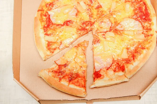 Gorący kawałek pizzy z topiącym się serem na rustykalnym drewnianym stole — Zdjęcie stockowe