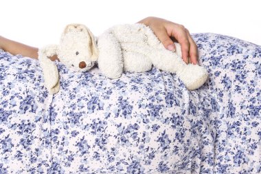 Mutlu hamile kız beyaz arka planda yatıyor.