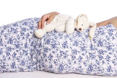 Mutlu hamile kız beyaz arka planda yatıyor.