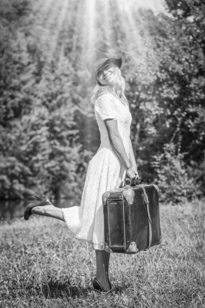 Ragazza felice con una valigia all'aperto al parco — Foto Stock