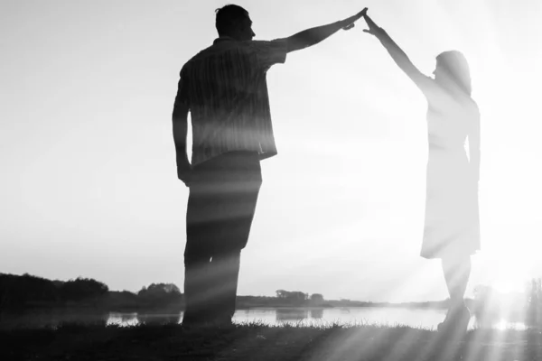 Gelukkig paar silhouet tegen een zonsondergang romantiek — Stockfoto