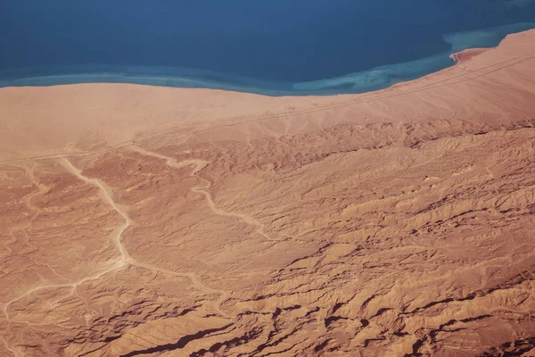 Земля и море из иллюминатора самолета — стоковое фото