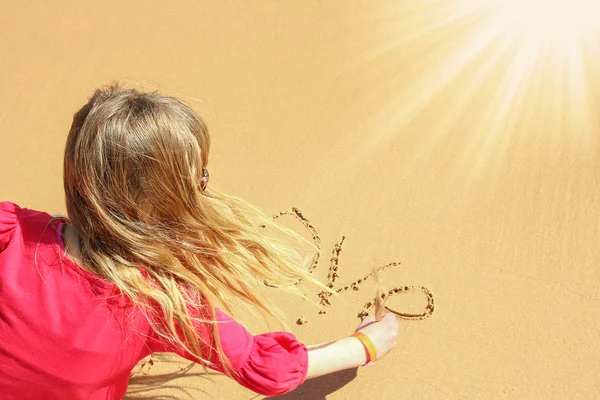 Happy Child drar på sanden nära havet bakgrund — Stockfoto