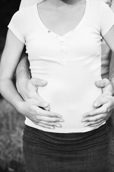 Gelukkige man met vrouw zwanger op de natuur in de zomer — Stockfoto