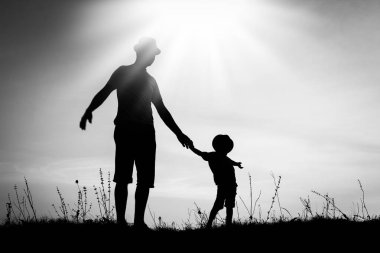 Çocuklu mutlu bir ebeveyn yaz siluetinde oynuyor.