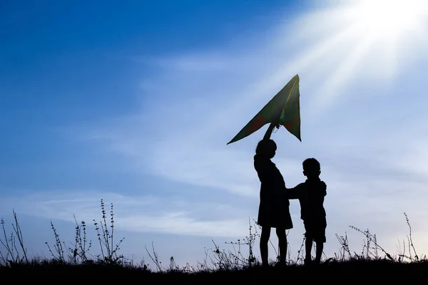 Šťastné děti hrají na přírodu letní silueta — Stock fotografie